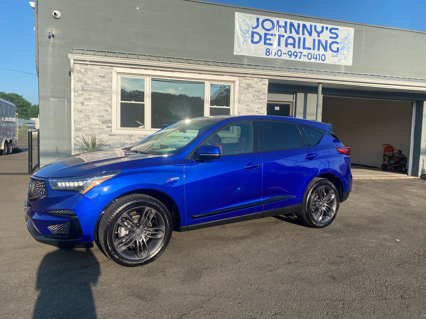 Royal blue Acura RDX A-Spec detailed in front of the shop