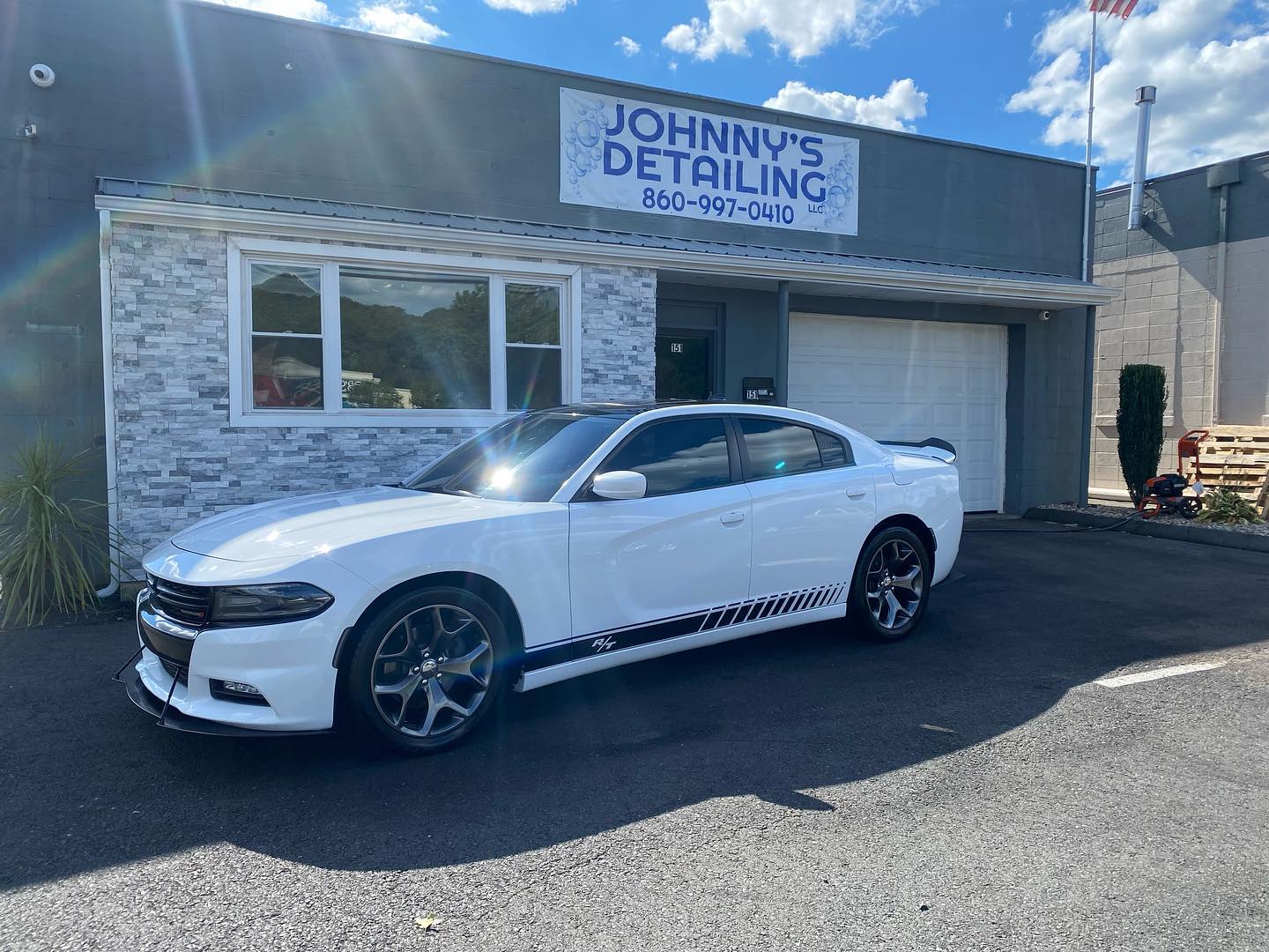White Dodge Charger R/T detailed in front of shop